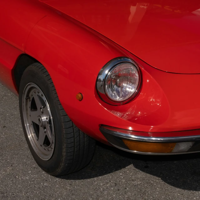 an old red car is parked in a parking lot