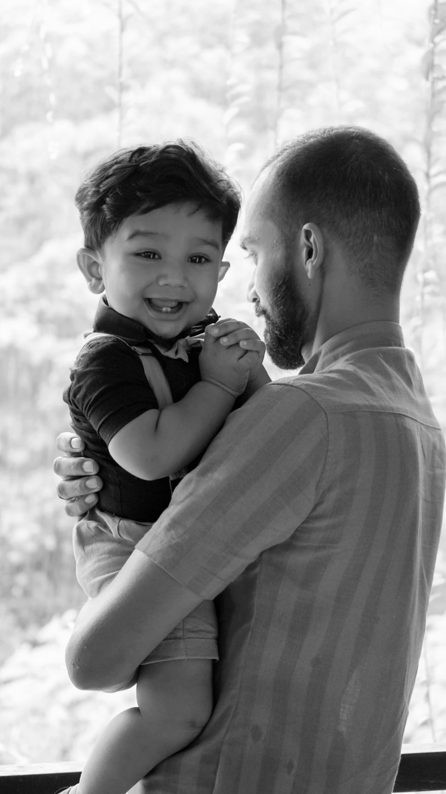 a young man holding a child with the caption that's so cute