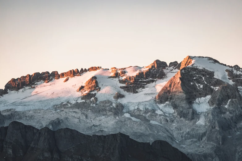 snow covered mountains with the sun just setting