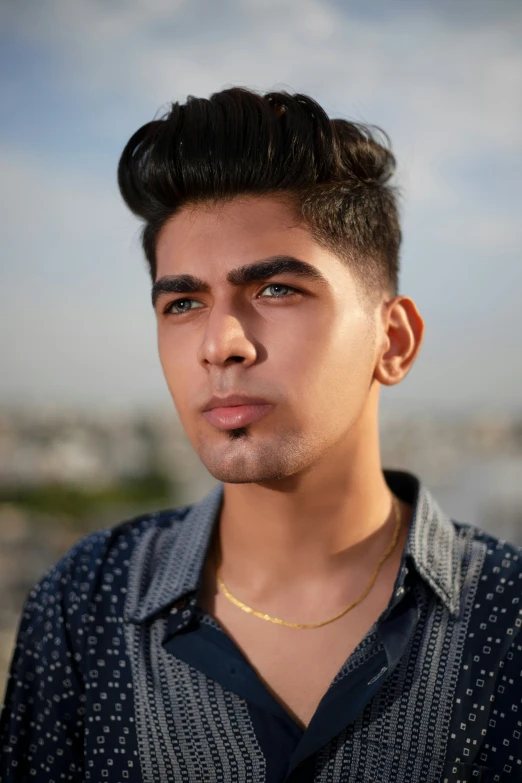 a young man wearing a collared shirt posing for a po