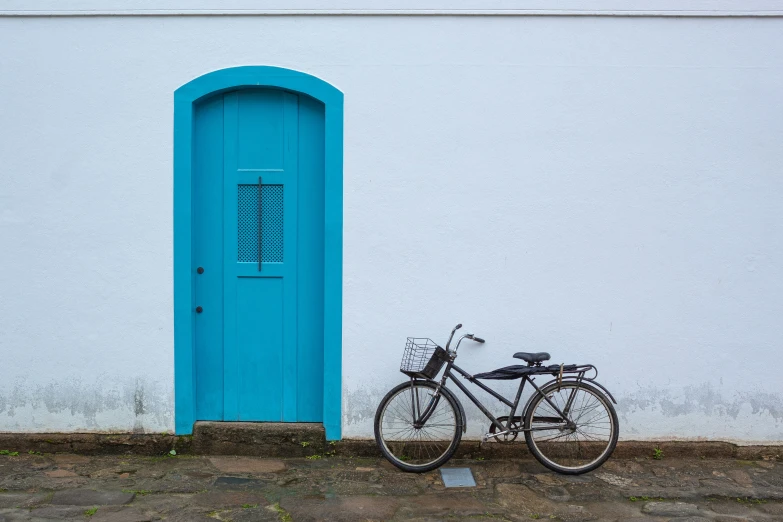 a bicycle parked next to a white building