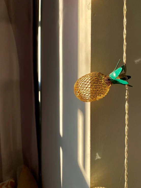 a gold bird statue on a string with lights