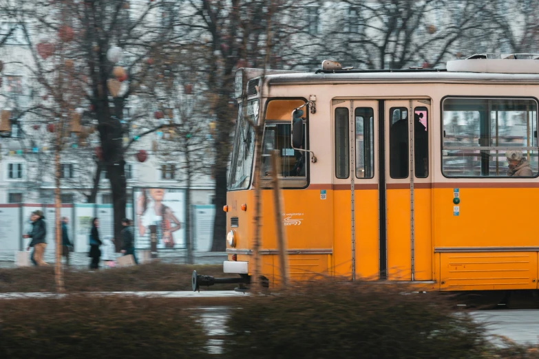 a yellow commuter bus driving down a street