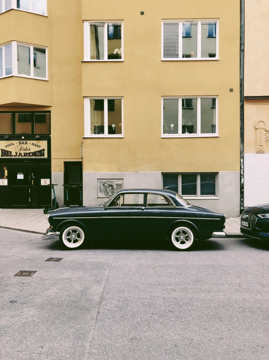 a black and white old car parked near a building