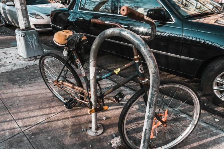 a bike  to a post while cars drive by