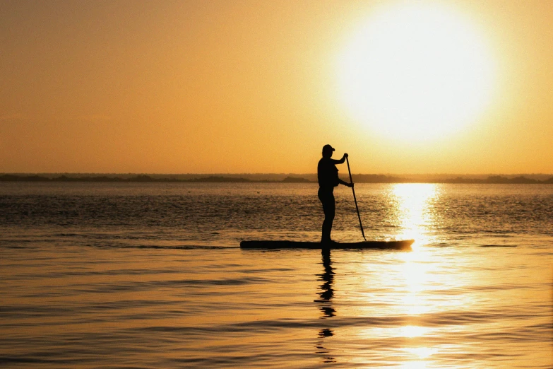 a man riding a paddle board on top of a lake