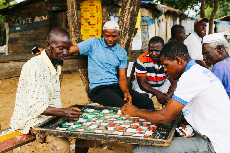 men sitting around playing with cupcakes outside