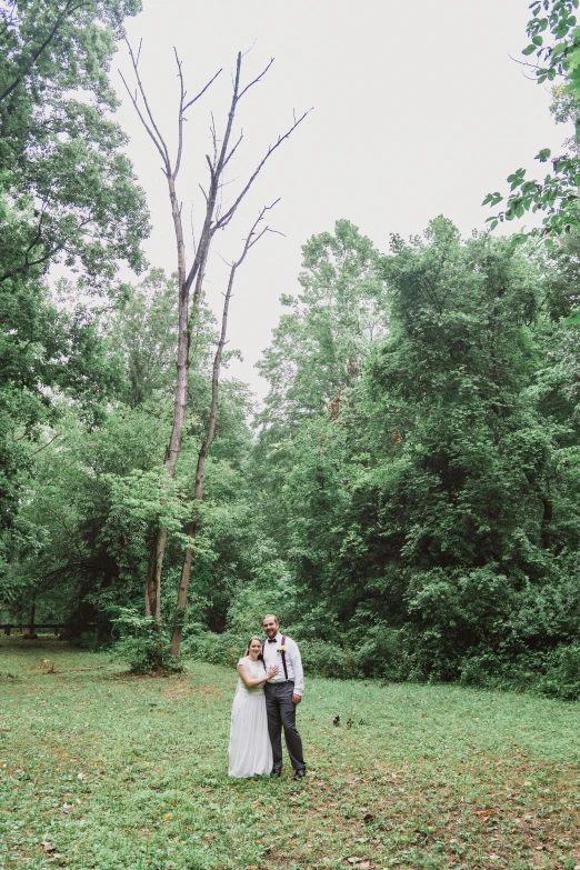 a man and woman standing in the grass