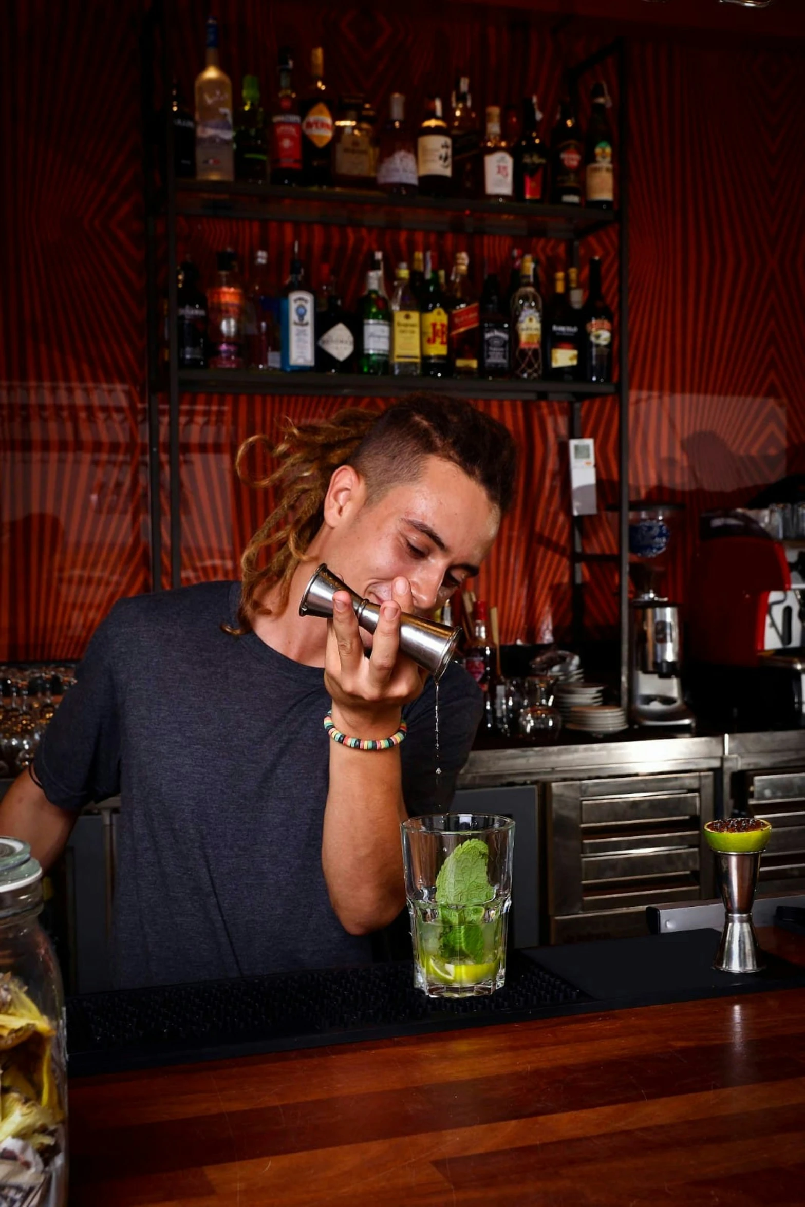 a young man behind the bar talking on his cell phone