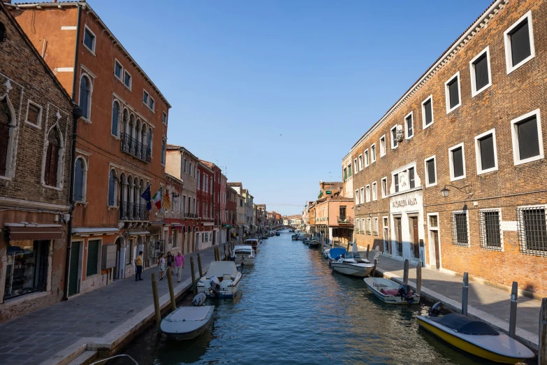 boats are docked on the river near an old building