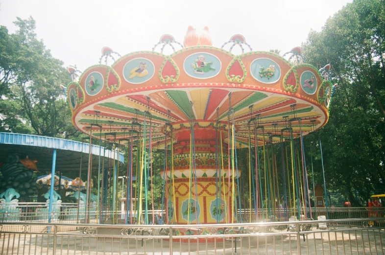 a colorful carousel with the lights on sits in a park