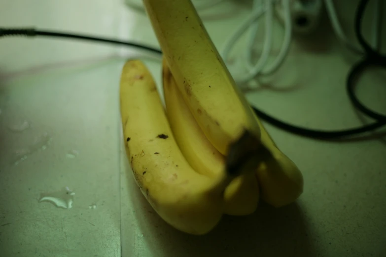 two bananas laying on a table, one being peeled