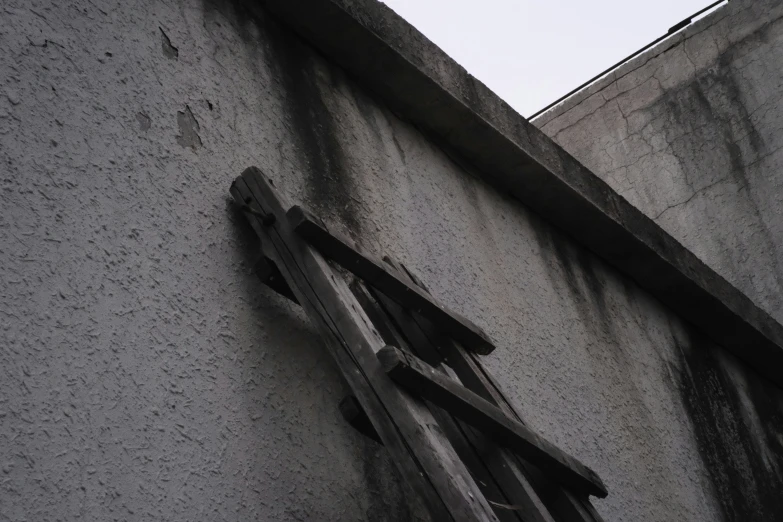 a view of a gray building with a broken window