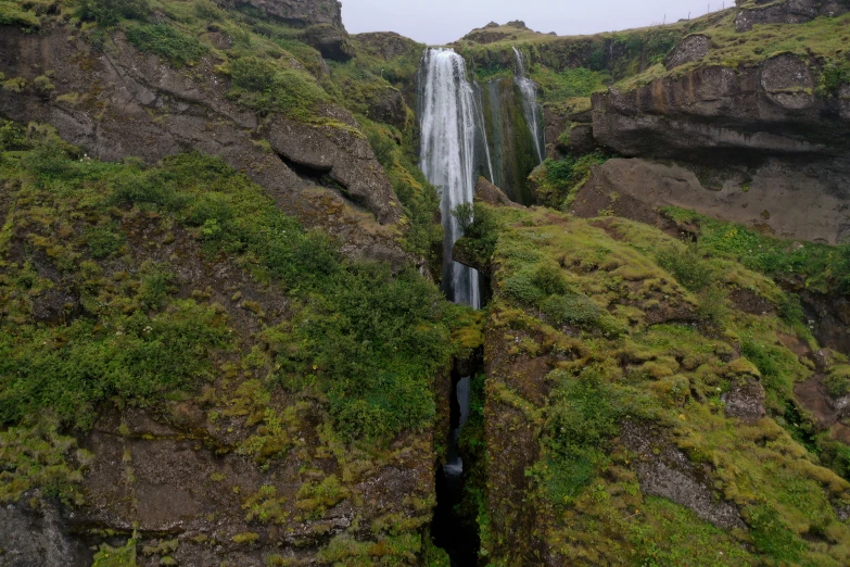 the waterfall is high on the side of the mountain