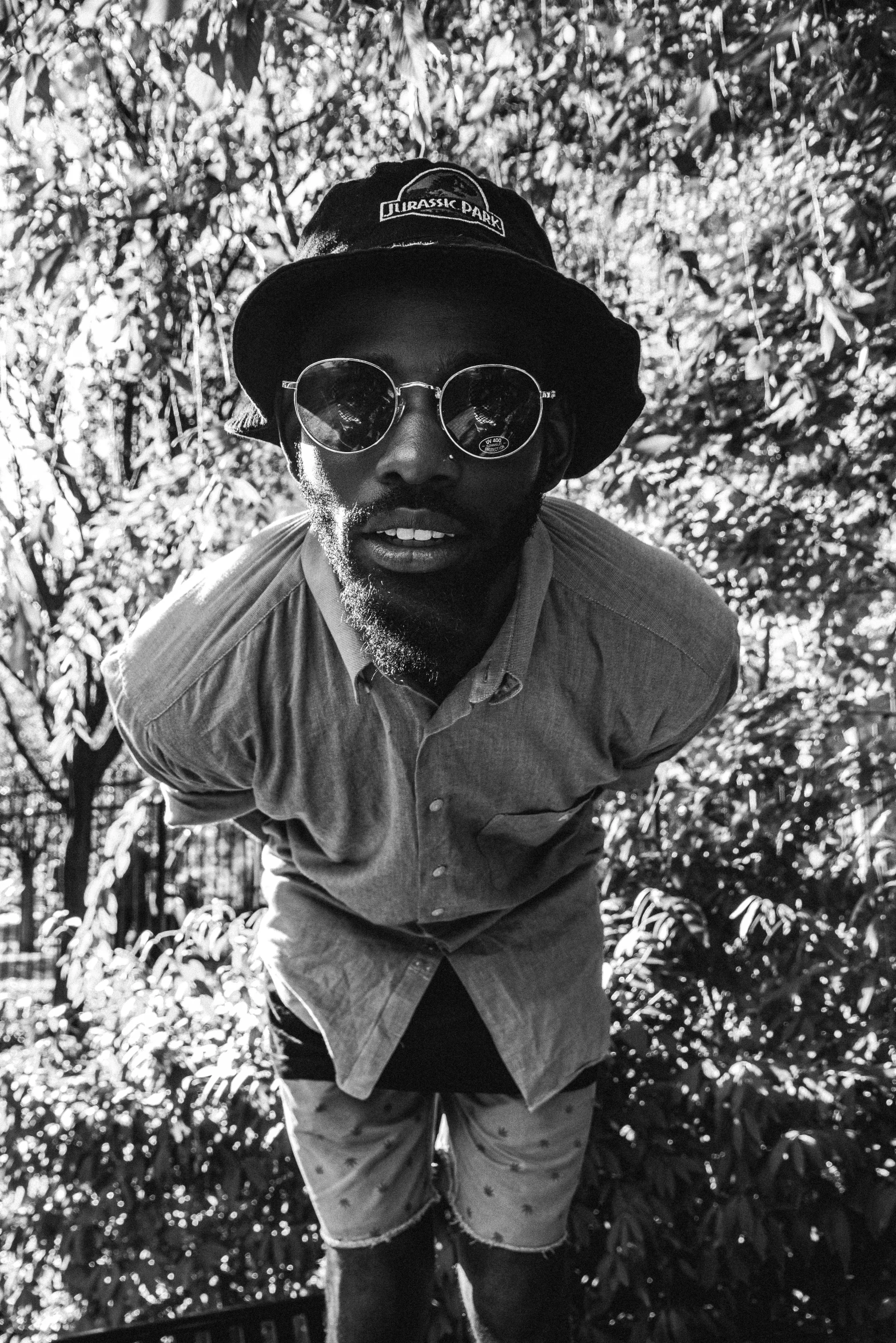 black man wearing sun glasses and a hat posing for the camera