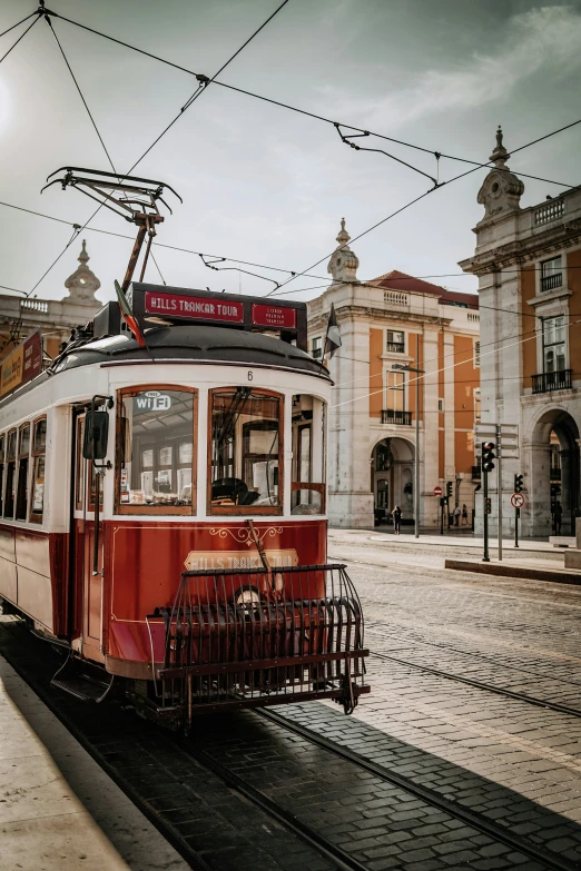 old streetcar car sitting on tracks in front of buildings