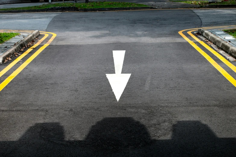 an empty parking lot with two arrow arrows painted on it