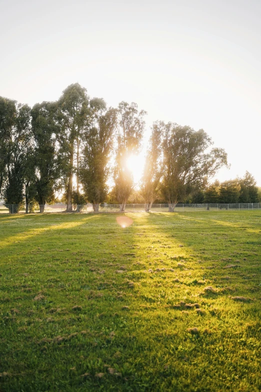 the sun is setting in an open field