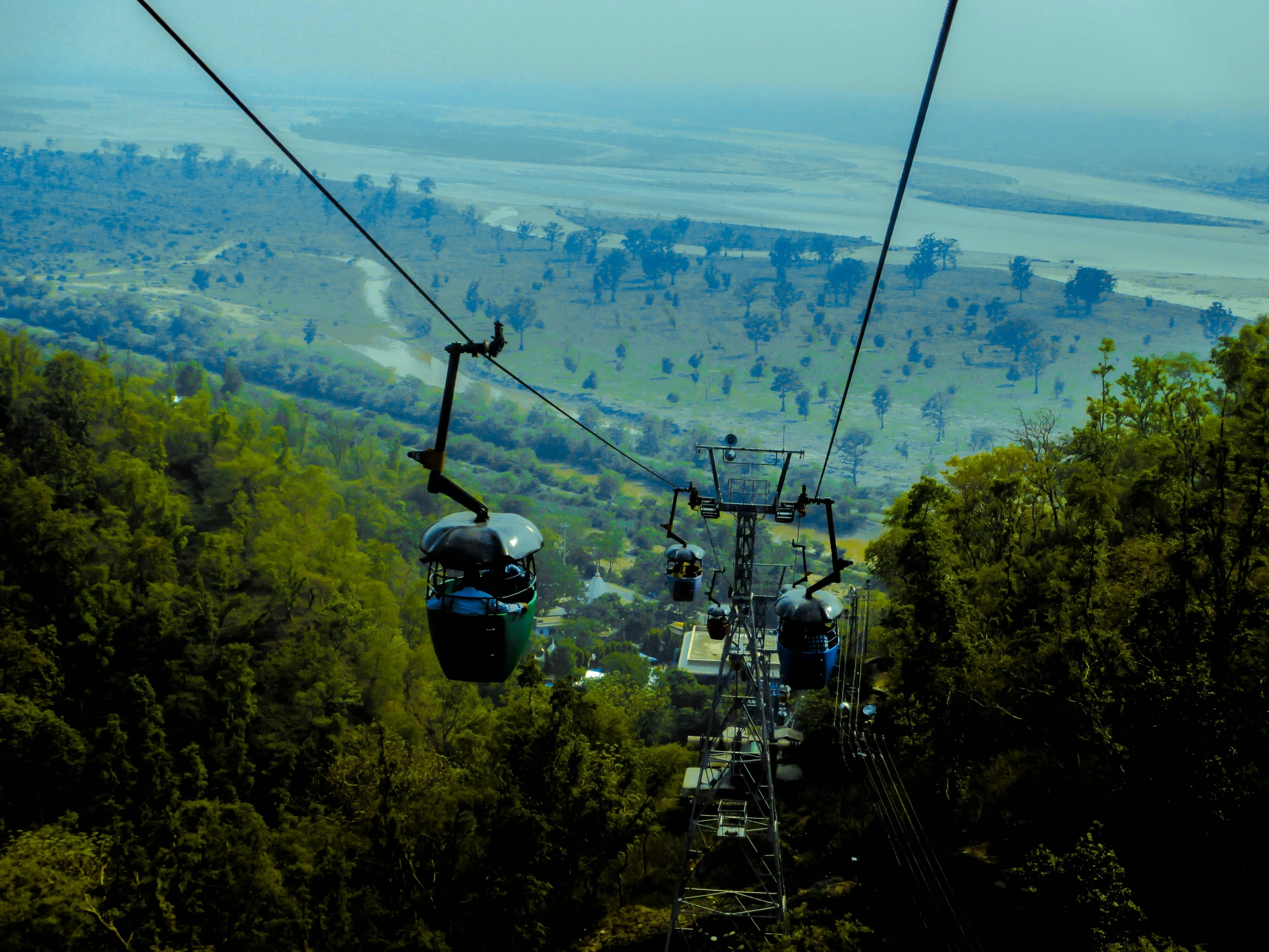 a couple of people ride a cable in the air