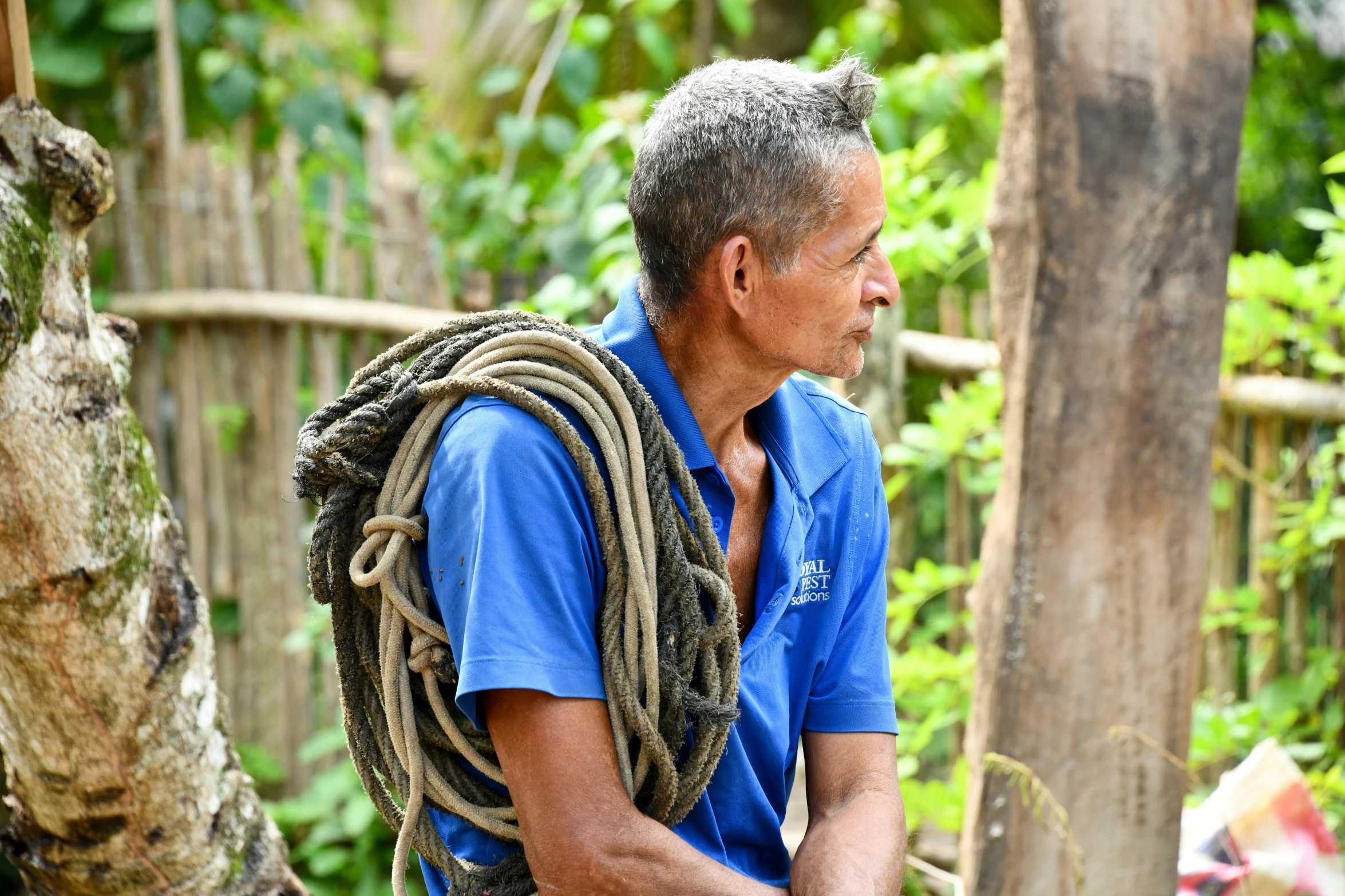 a man wearing a backpack holding a rope across his back