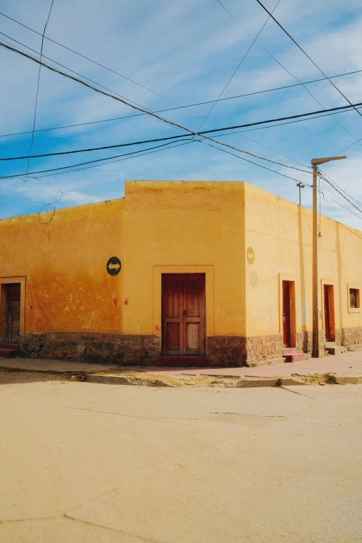 the front entrance to an adobe - style building with power lines in the background