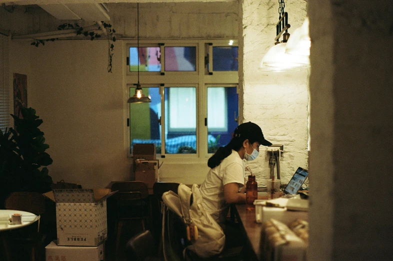 a person sitting at a table using a laptop computer