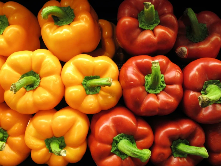 several bell peppers, oranges and broccoli on display