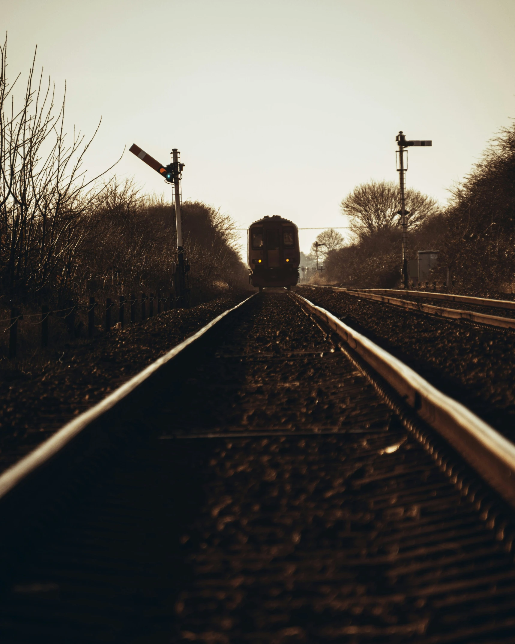 a train going down the tracks in the middle of an empty field