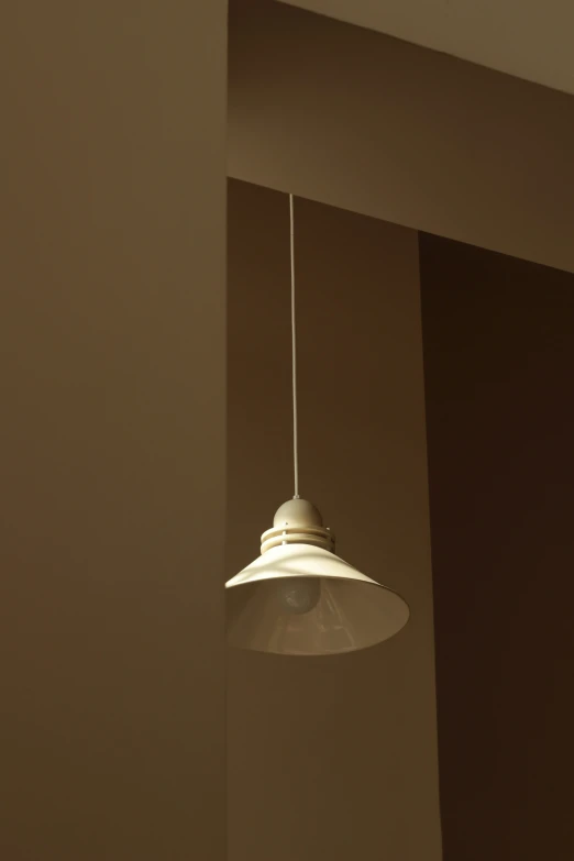 a white light fixture mounted above a white wall