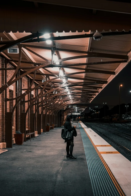 a person walking down an empty platform with a train