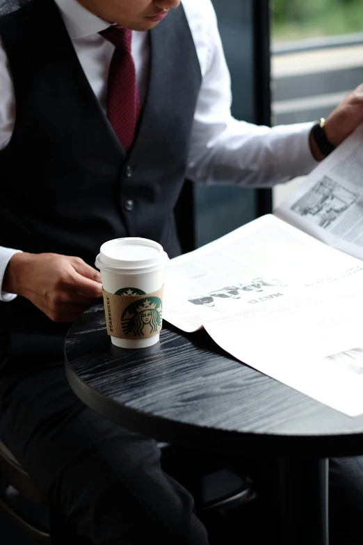 a man sitting at a table reading a paper