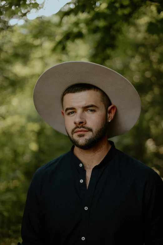 a bearded man in a hat poses for a picture