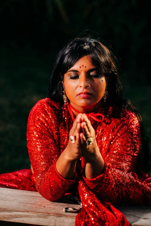 a woman wearing red clothing sitting on a bench