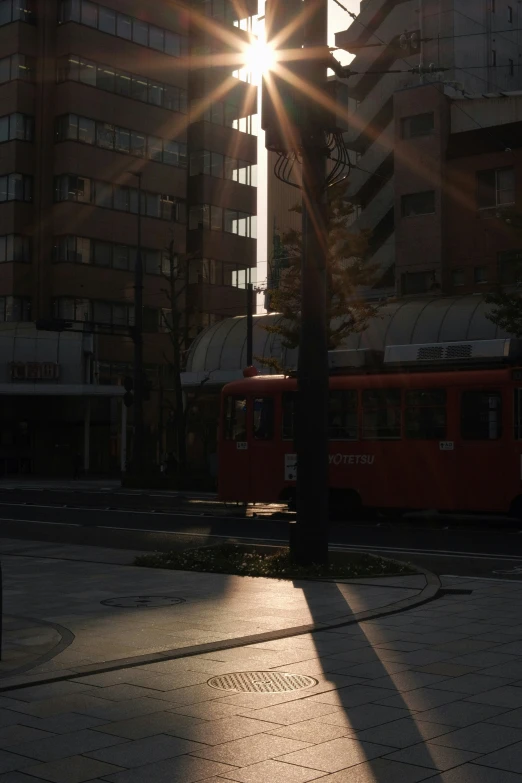 a yellow train going down a road and some buildings