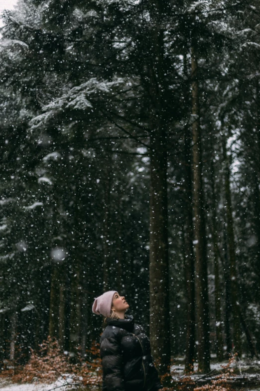 a woman standing in front of snowy woods