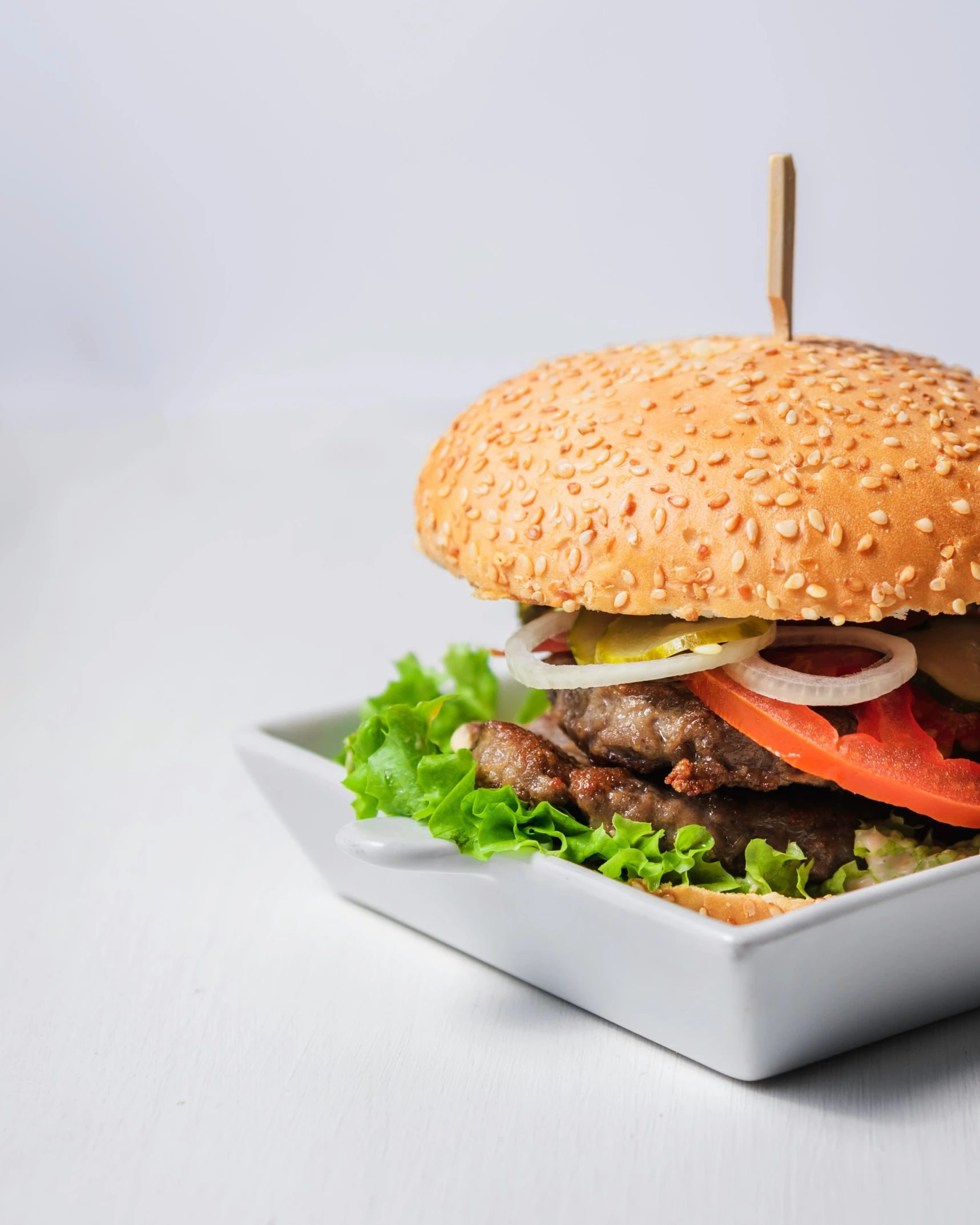 a hamburger in a bowl with an extra large bun