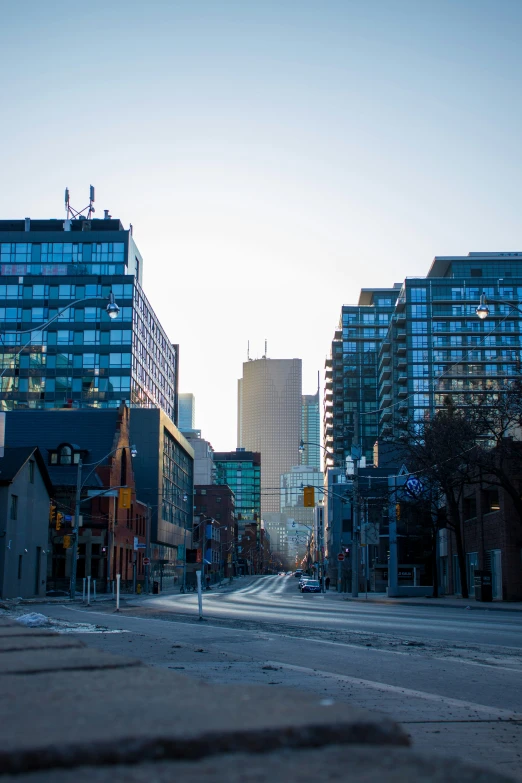 a view of a deserted street in a city with skyscrs