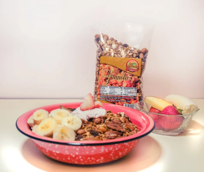 a bowl of granola is on the table with fruit and nuts