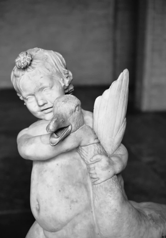 a statue of a baby sitting on its back with a teddy bear