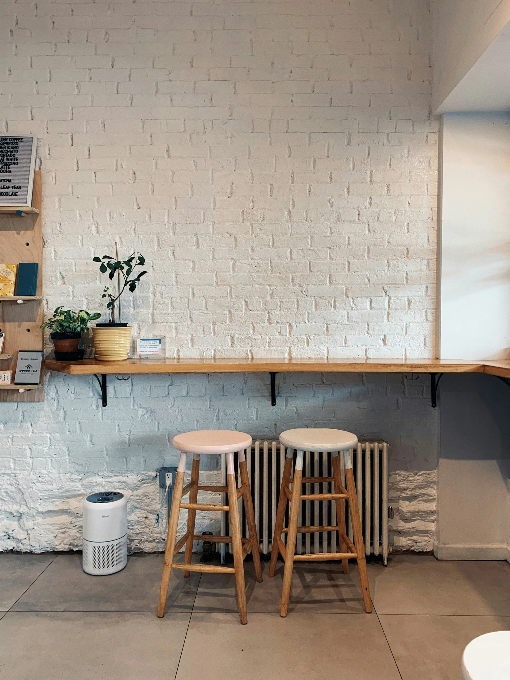 two stools sit beside a wall that has a brick design