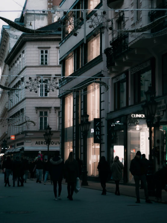 pedestrians walk through an urban city at night