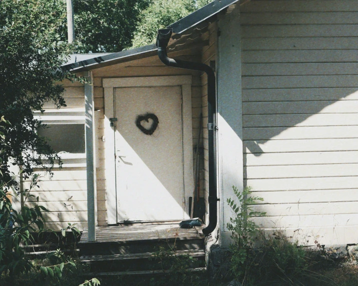 a white door with a heart on it in front of a house