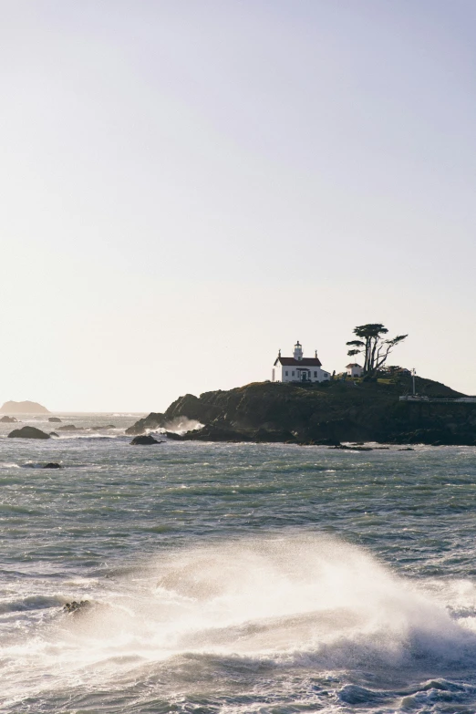 a small island on the top of a cliff with some waves