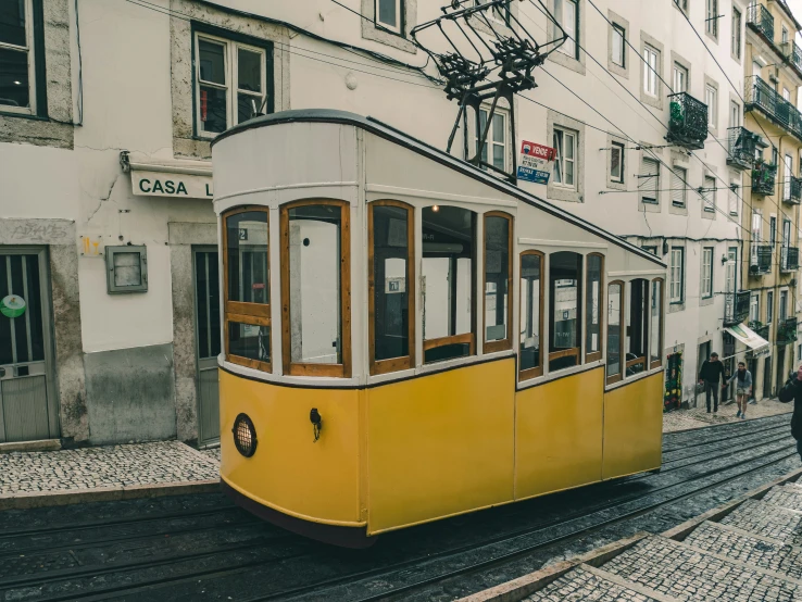 people standing on the ground and taking pos in front of an old cable car