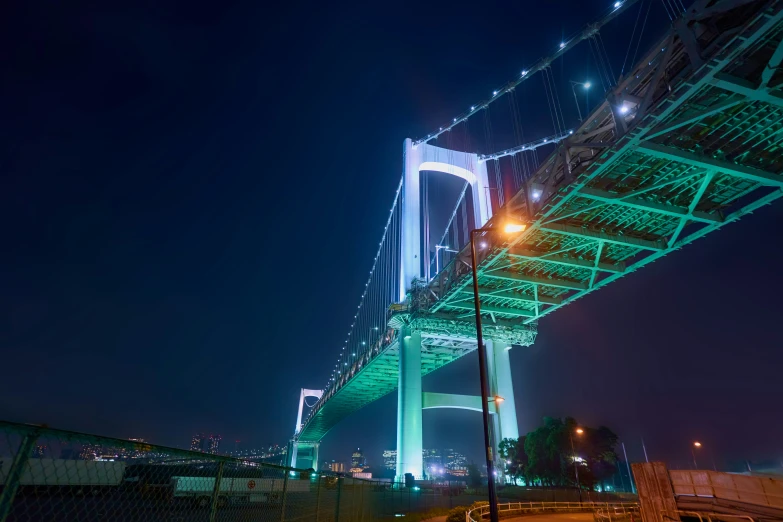 the green lights are on the bridge at night