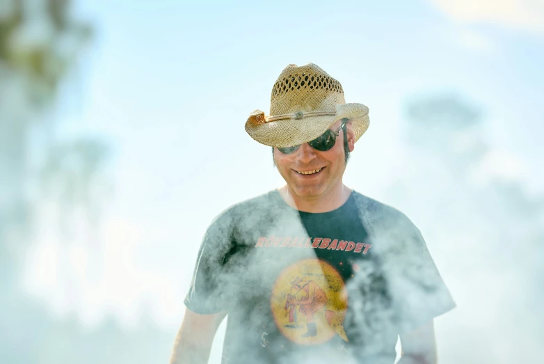 a man in a straw hat and sunglasses smiling