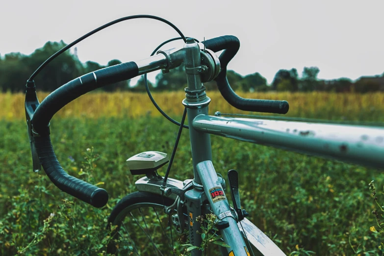 a close up of a bicycle parked in the grass