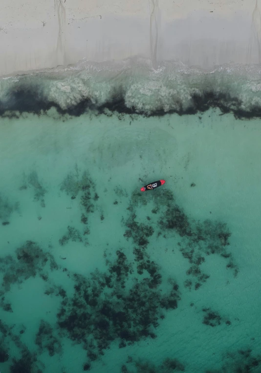 an aerial view of the ocean with two people in the boat