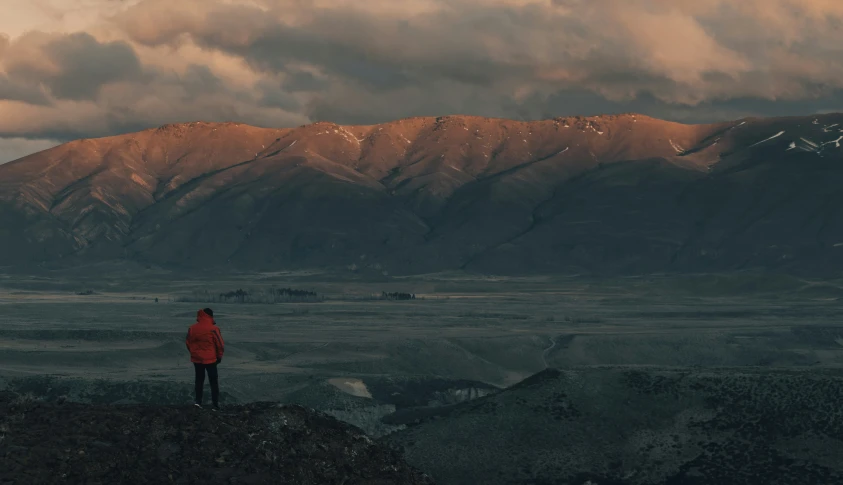 a person looking over a mountainous field