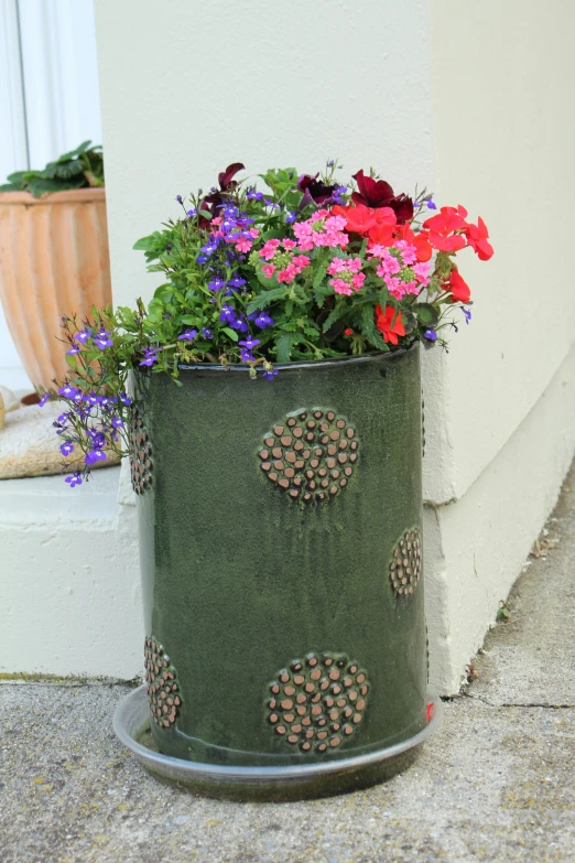 a flower pot with colorful flowers and greenery